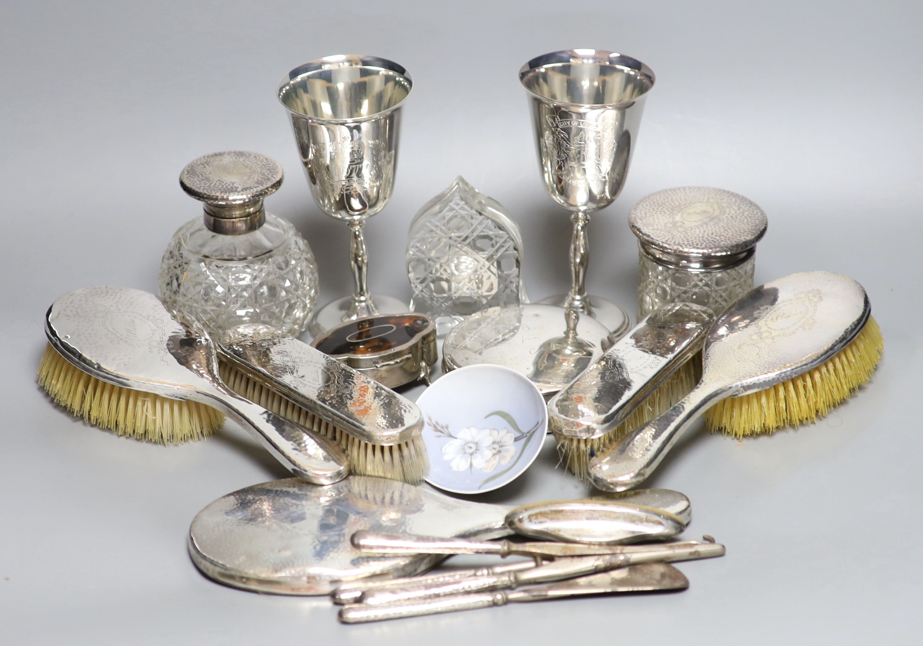 A George V hammered silver ten piece dressing table set with tray, engraved 'Stella' and six other items including a silver circular powder box?, a tortoiseshell mounted trinket box and two plate goblets.